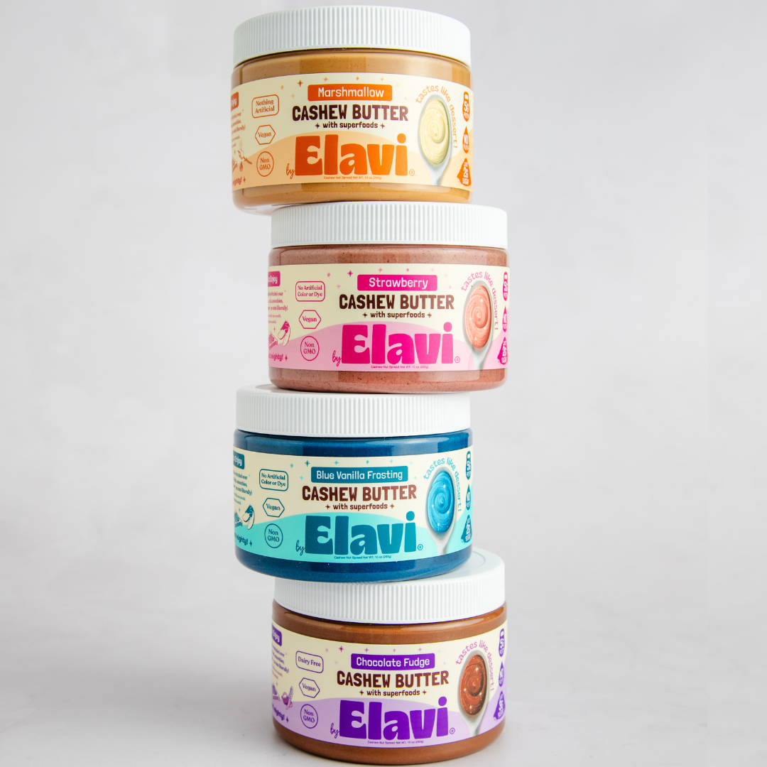 Front view of four stacked Elavi cashew butter jars showing colorful labels on a light gray background