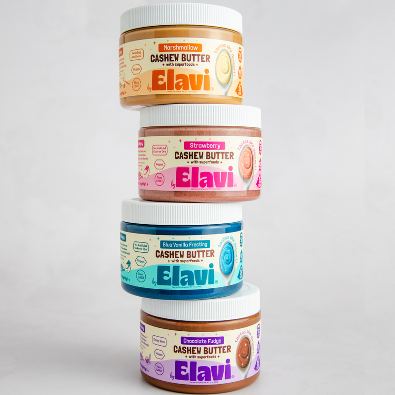 Front view of four stacked Elavi cashew butter jars showing colorful labels on a light gray background