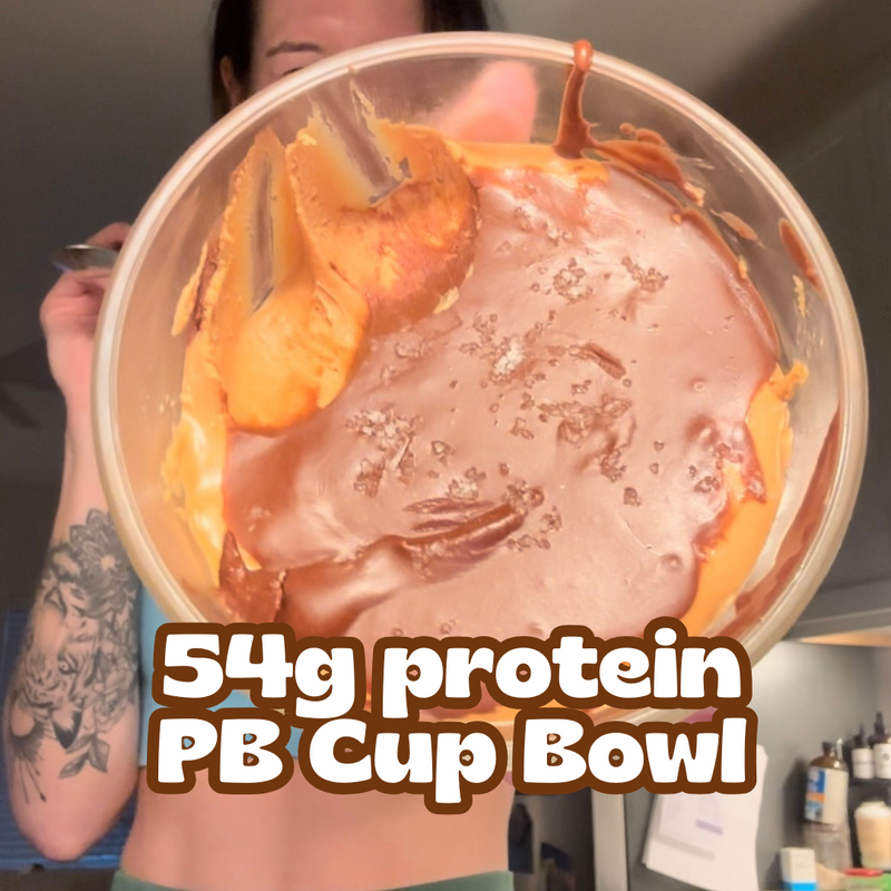 Person holding a peanut butter cup bowl topped with chocolate in a kitchen, close up, overlaid text 54g protein PB Cup Bowl